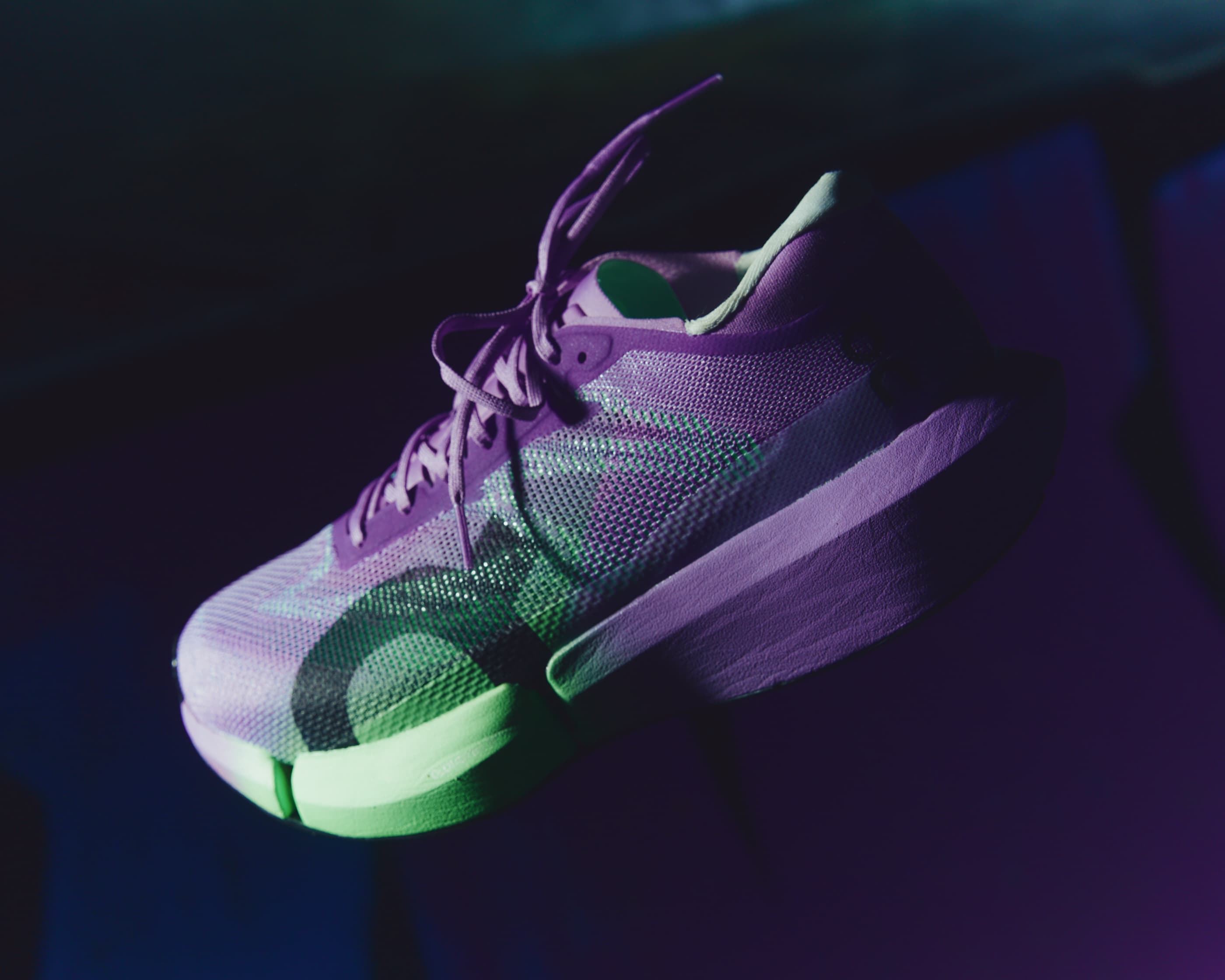 The On Cloudboom Strike 2 lit in purple and green